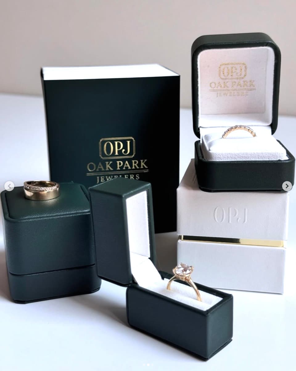 Oak Park Jewelers — custom PU leather ring boxes in forest green and white with gold foil stamped logo and metal hardware